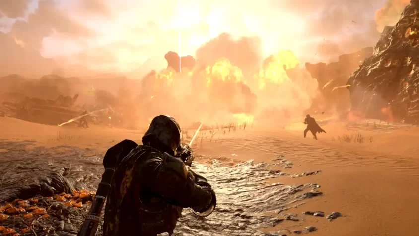 Игрок HellDivers 2 в бою на пустынной планете с взрывами в фоне.