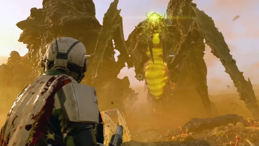 Солдат в броне смотрит на огромного врага в Helldivers 2.