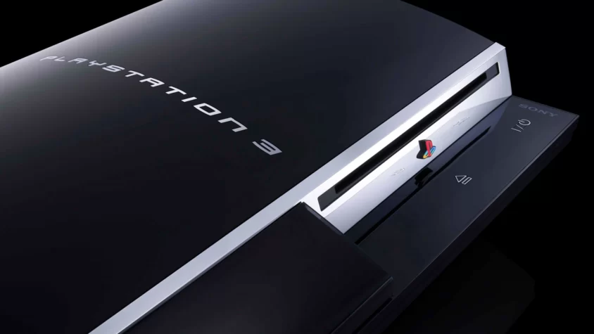 Консоль Sony PlayStation 3 крупным планом на чёрном фоне