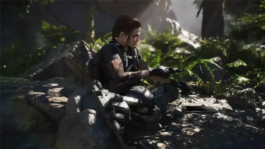 Солдат отдыхает на камнях в тропическом лесу в Tom Clancy's Ghost Recon Breakpoint
