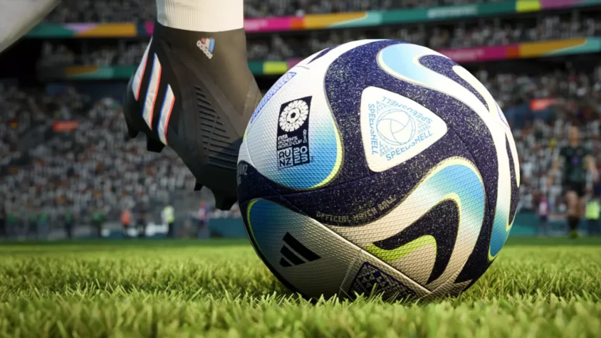Мяч чемпионата мира FIFA 2023 на поле с бутсами игрока
