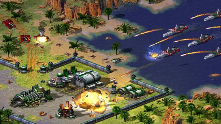 Сцена из Command & Conquer: Red Alert 2 с танками и кораблями, взрывающими друг друга, и горящей базой