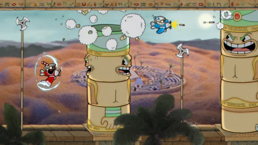 Персонажи Cuphead сражаются с огромной статуей в древнем храме, наполненном песчаным ландшафтом