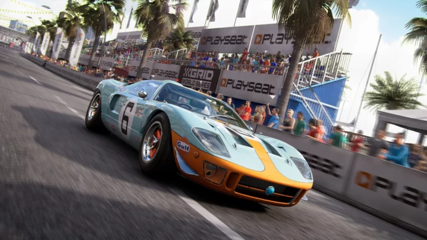 Гоночный автомобиль Ford GT, мчащийся по трассе с рекламой Playseat и толпой зрителей, восхищённых его мастерством.