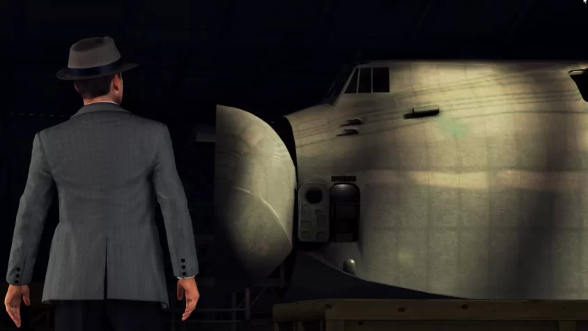 Герой L.A. Noire стоит перед огромным самолётом, явно в раздумьях о том, как это связано с расследованием