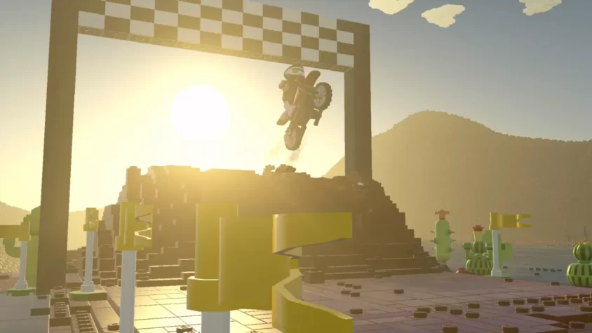 Мотоциклист выполняет трюк на фоне финишной черты в мире Lego Worlds, с ярким солнцем
