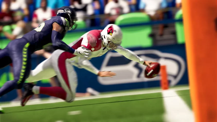Игрок с мячом падает под защитником в Madden NFL 21