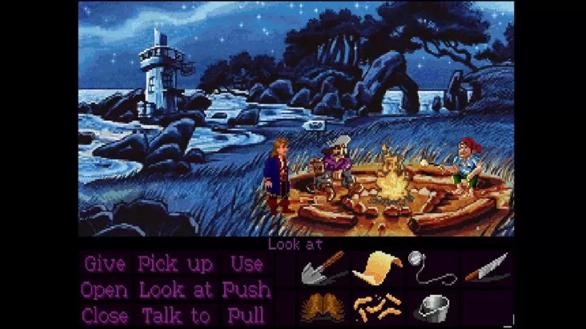 Персонажи сидят у костра на берегу в игре Monkey Island 2