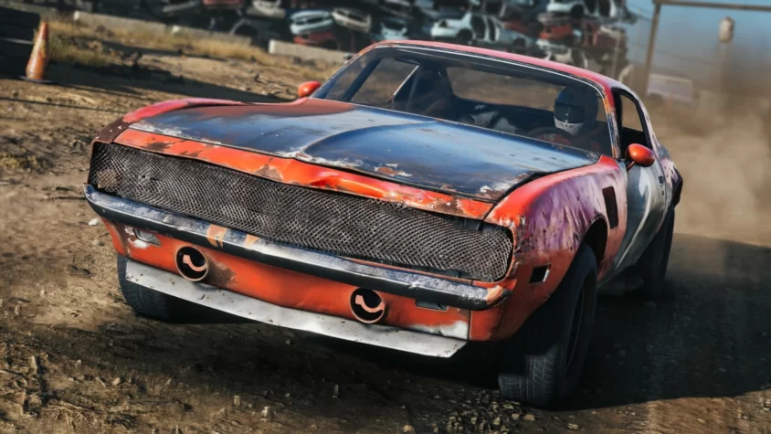 Красная машина в Wreckfest 2, готовая к столкновению среди свалки автомобилей